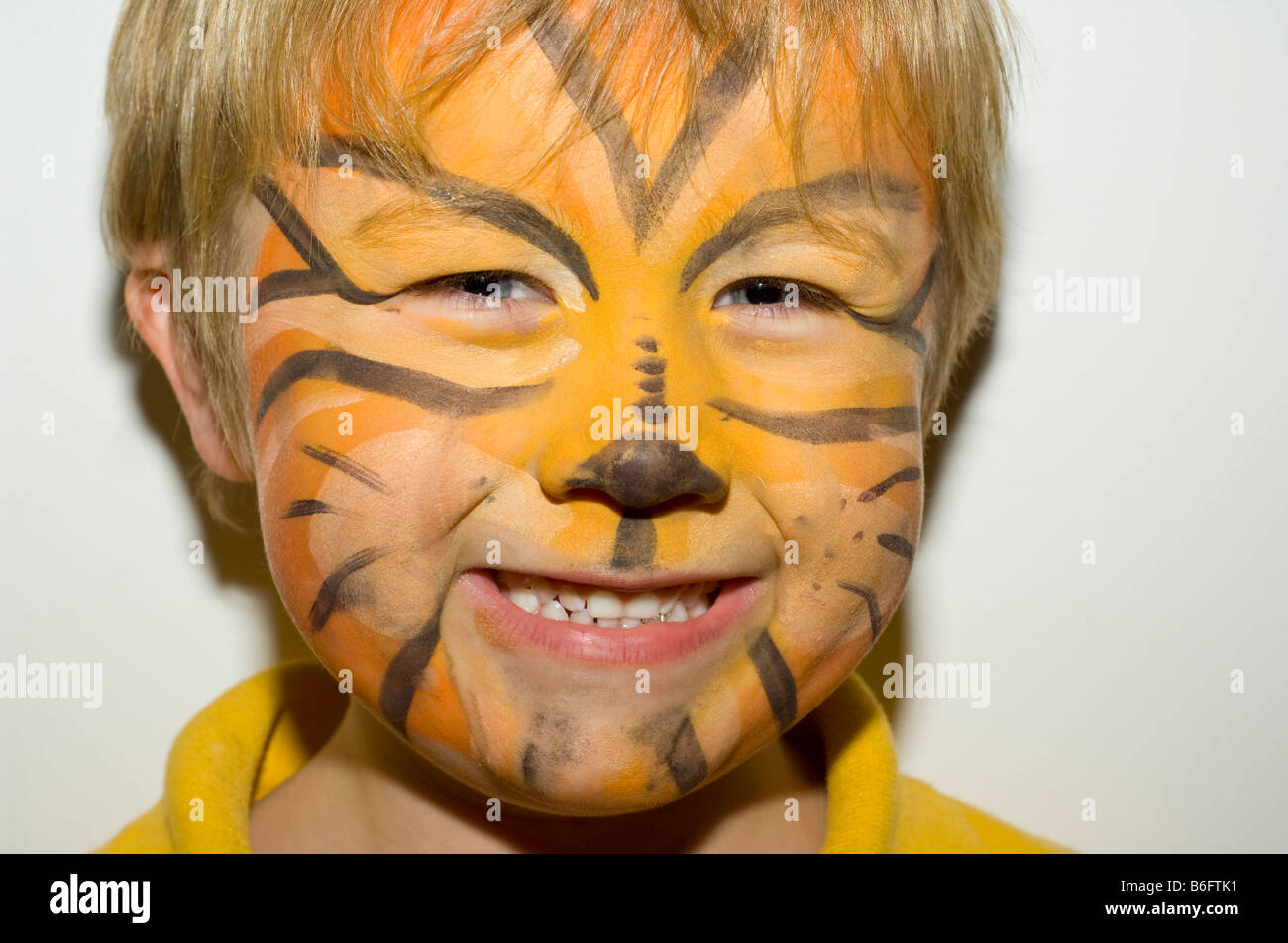 Giovani cinque anno vecchio ragazzo con la faccia dipinta con pitture facciali Foto Stock