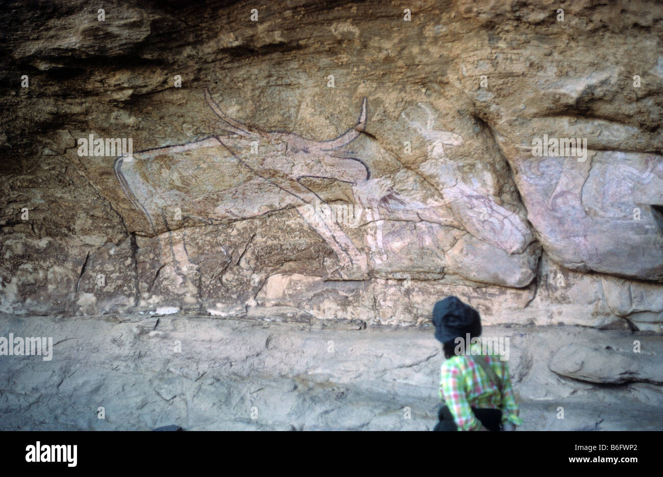 Donna osservando un disegno di alci come animali tra rock affreschi dipinti a Sefar Tassili N Ajjer plateau sopra Djanet Foto Stock