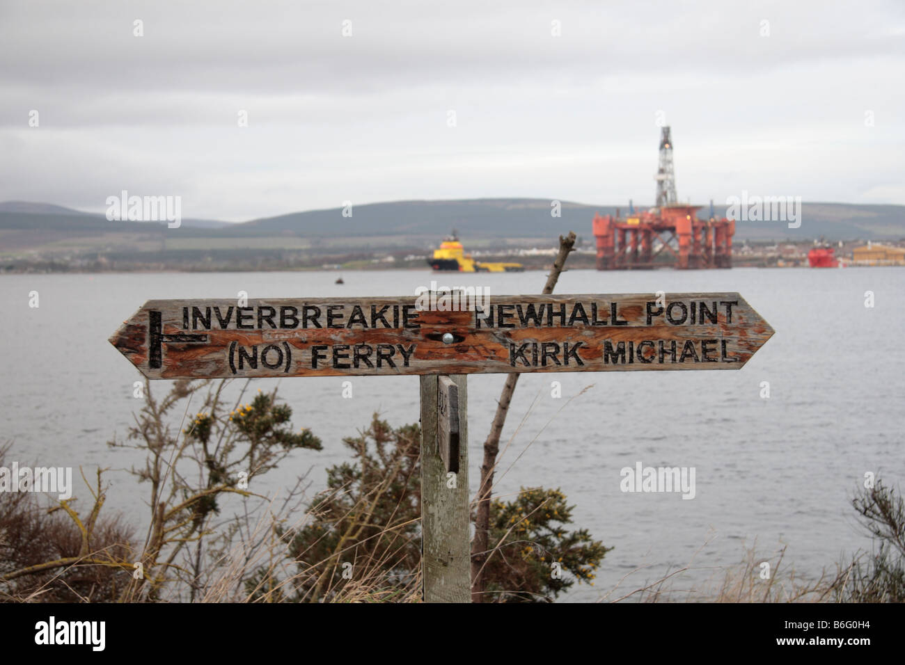 Cartello stradale sulla Cromarty Firth a lato della Black Isle nelle Highlands della Scozia La Essar Wildcat rig in background Foto Stock
