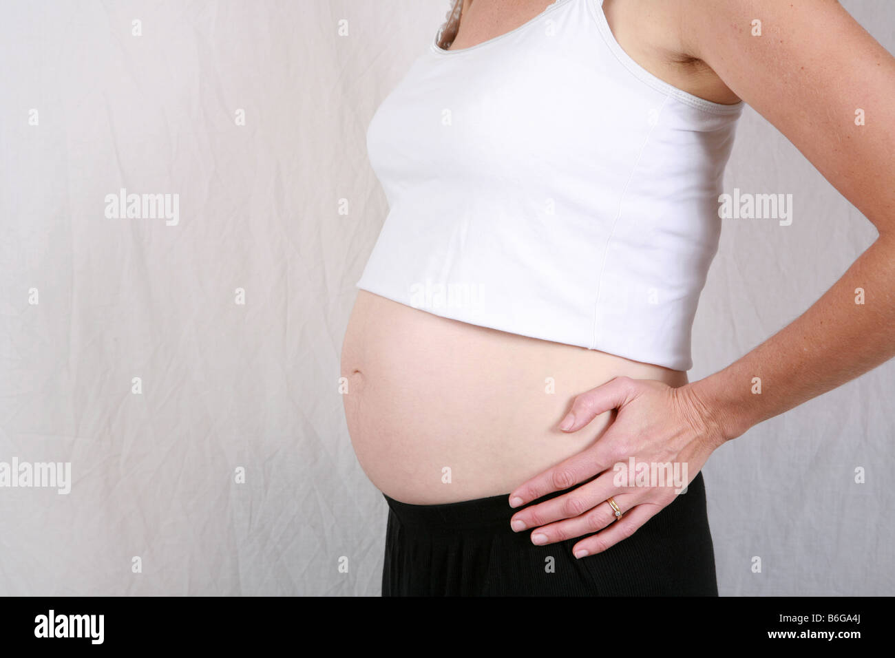 Primo piano della gravidanza stomaco womans bump a 24 settimane 6 mesi di gestazione sei di una serie di dieci time lapse immagini di gravidanza Foto Stock