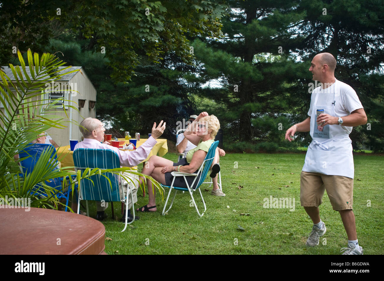 Riunione di famiglia insieme. Grigliare hamburger, hot dog, il pollo e altri cibi saporiti. Foto Stock