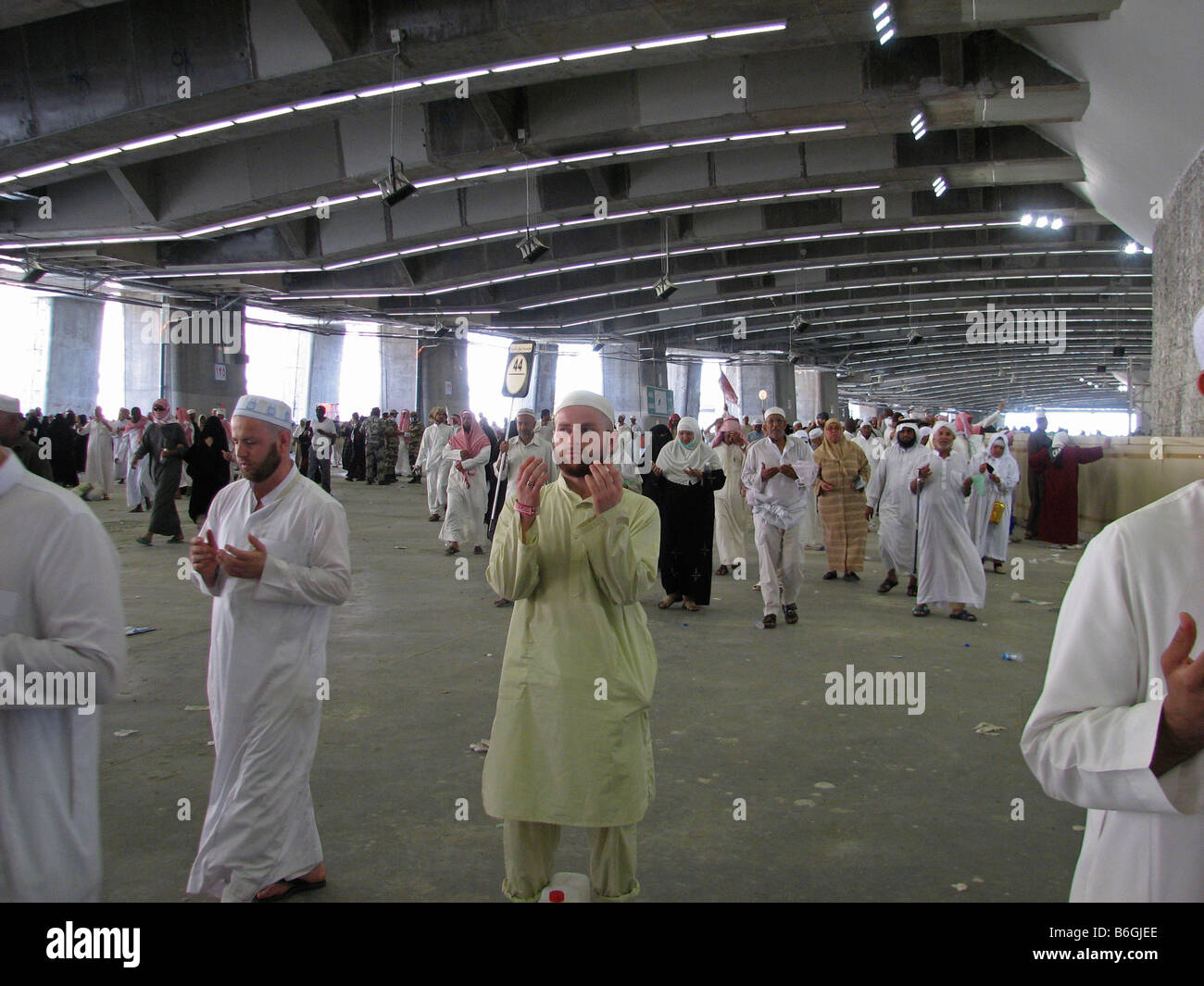 Pellegrini in preghiera accanto a uno dei tre pilastri che symbolices il diavolo Makkah Arabia Saudita Foto Stock