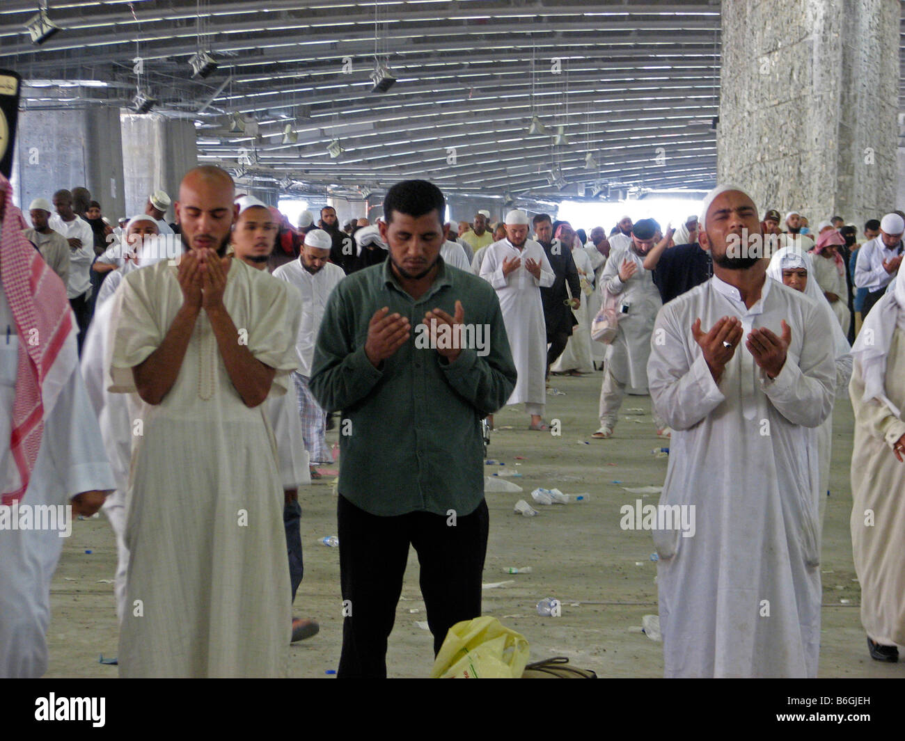 Pellegrini in preghiera accanto a uno dei tre pilastri che symbolices il diavolo Makkah Arabia Saudita Foto Stock