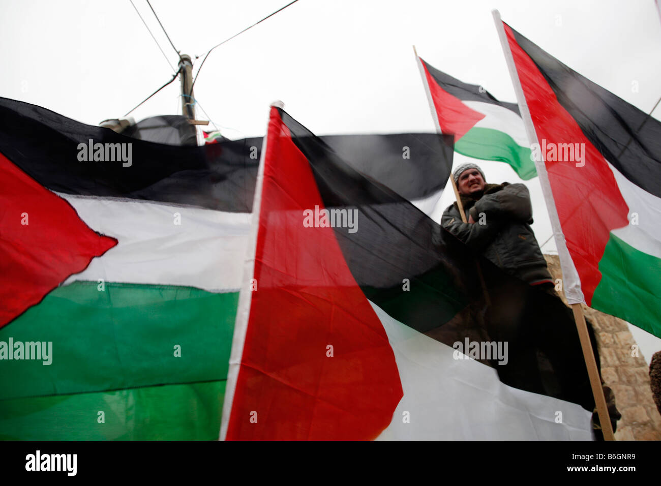 I dimostranti palestinesi battenti bandiere palestinesi nel villaggio di Bilin, vicino a Ramallah in Cisgiordania. Foto Stock