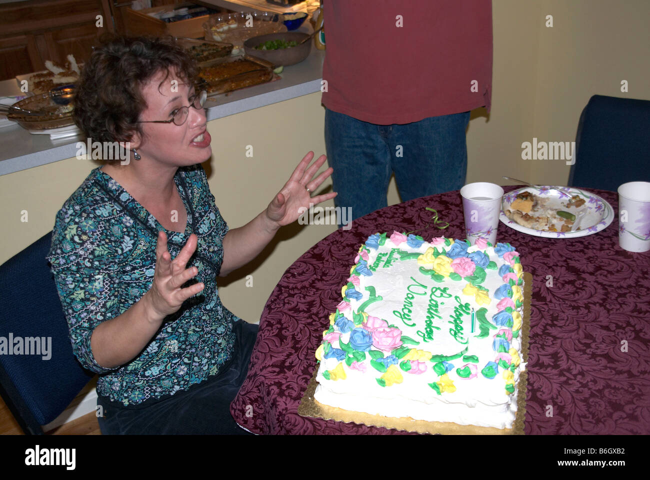 La donna reagisce ad una sorpresa torta di compleanno Foto Stock
