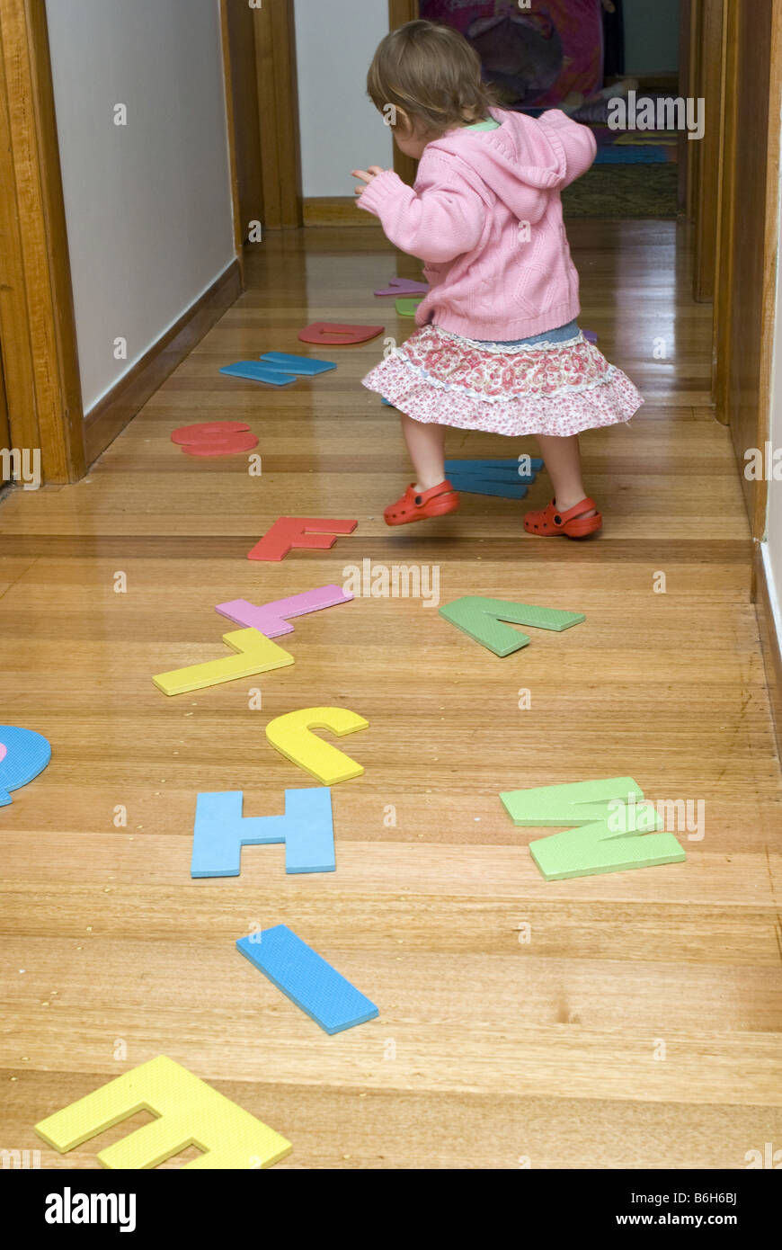 Due anni di ragazza che gioca con grande alfabeto di schiuma lettere Foto Stock