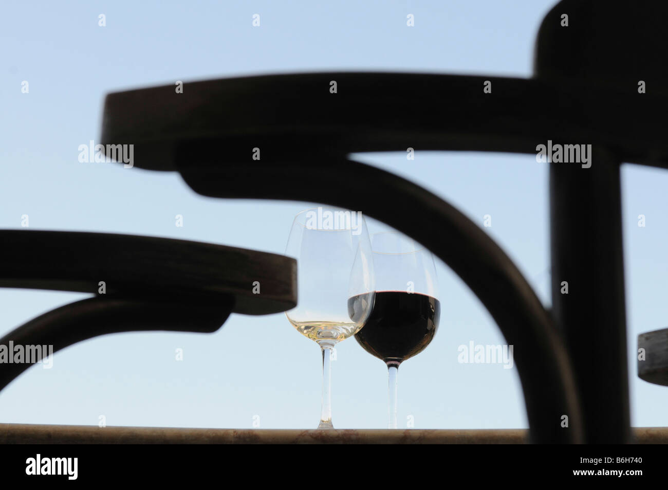 Due bicchieri di vino con vino rosso e bianco di luce sullo sfondo blu Foto Stock