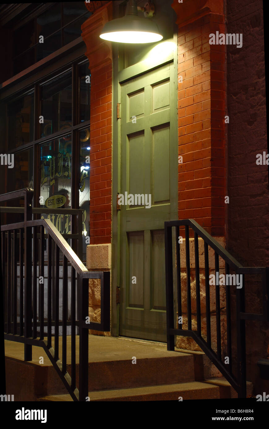 Sportello Verde e scale con luce shinging sulla porta Foto Stock