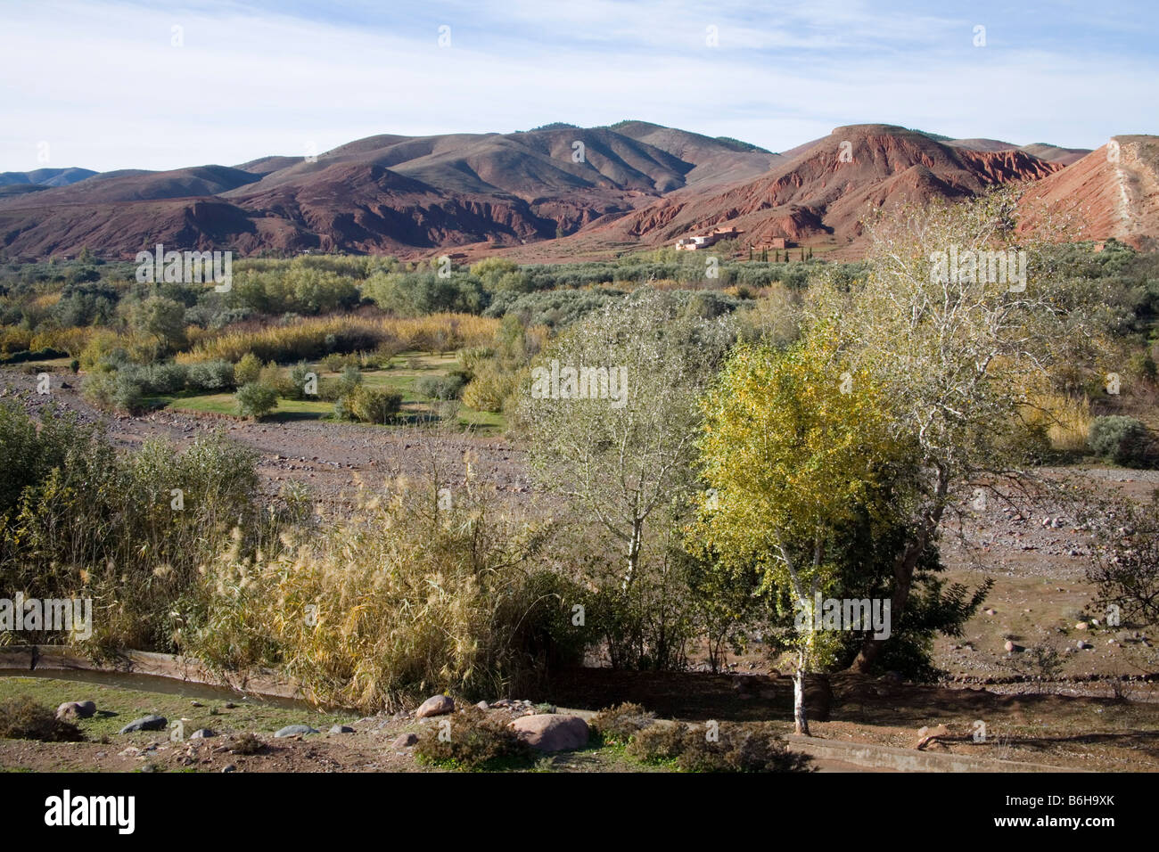 Il Marocco in Nord Africa dicembre guardando attraverso una valle nelle colline ai piedi dell'Alto Atlante verso capanne di fango di un villaggio berbero Foto Stock