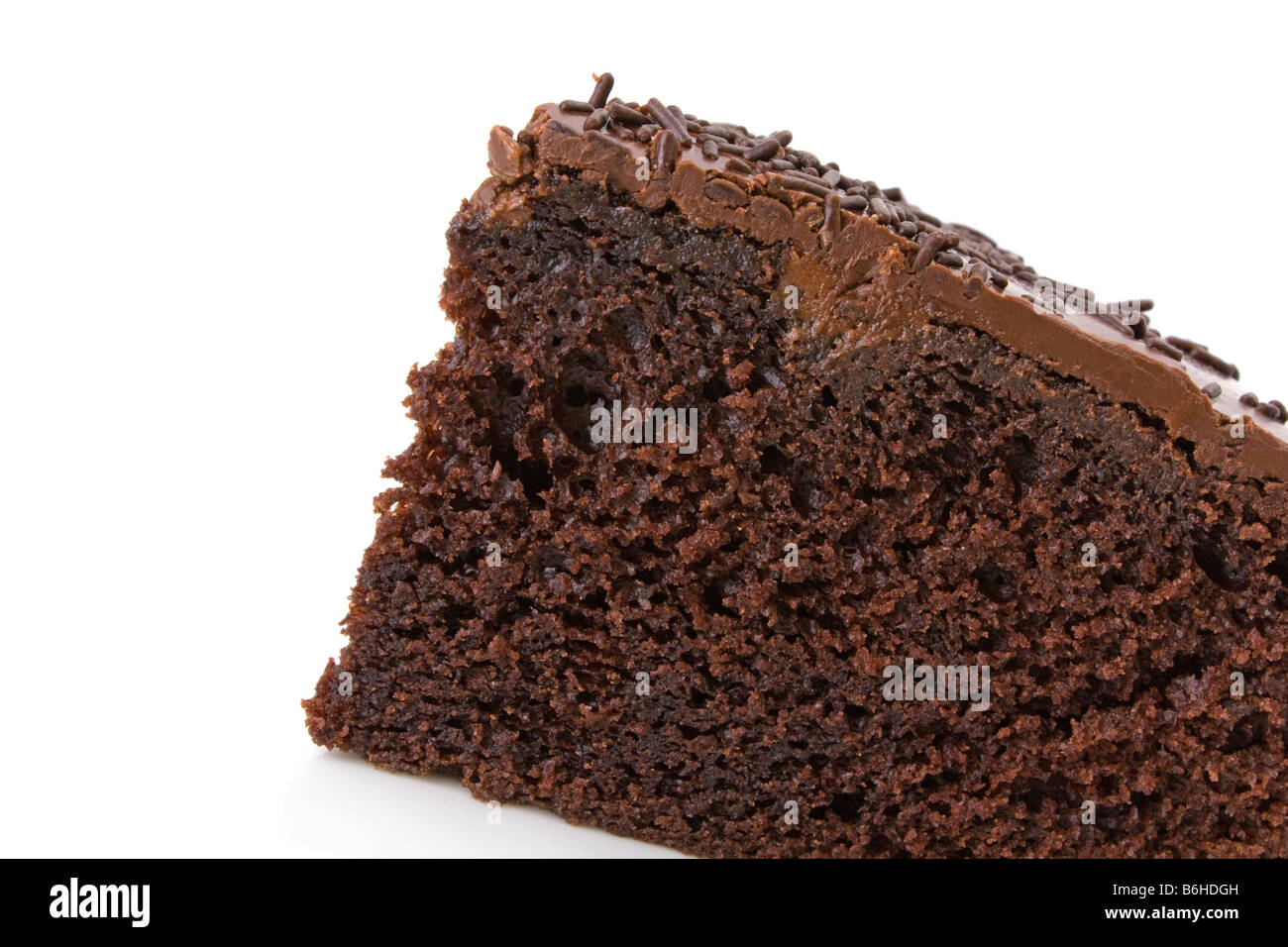 Fetta di torta al cioccolato con spruzzi di dettaglio su bianco Foto Stock