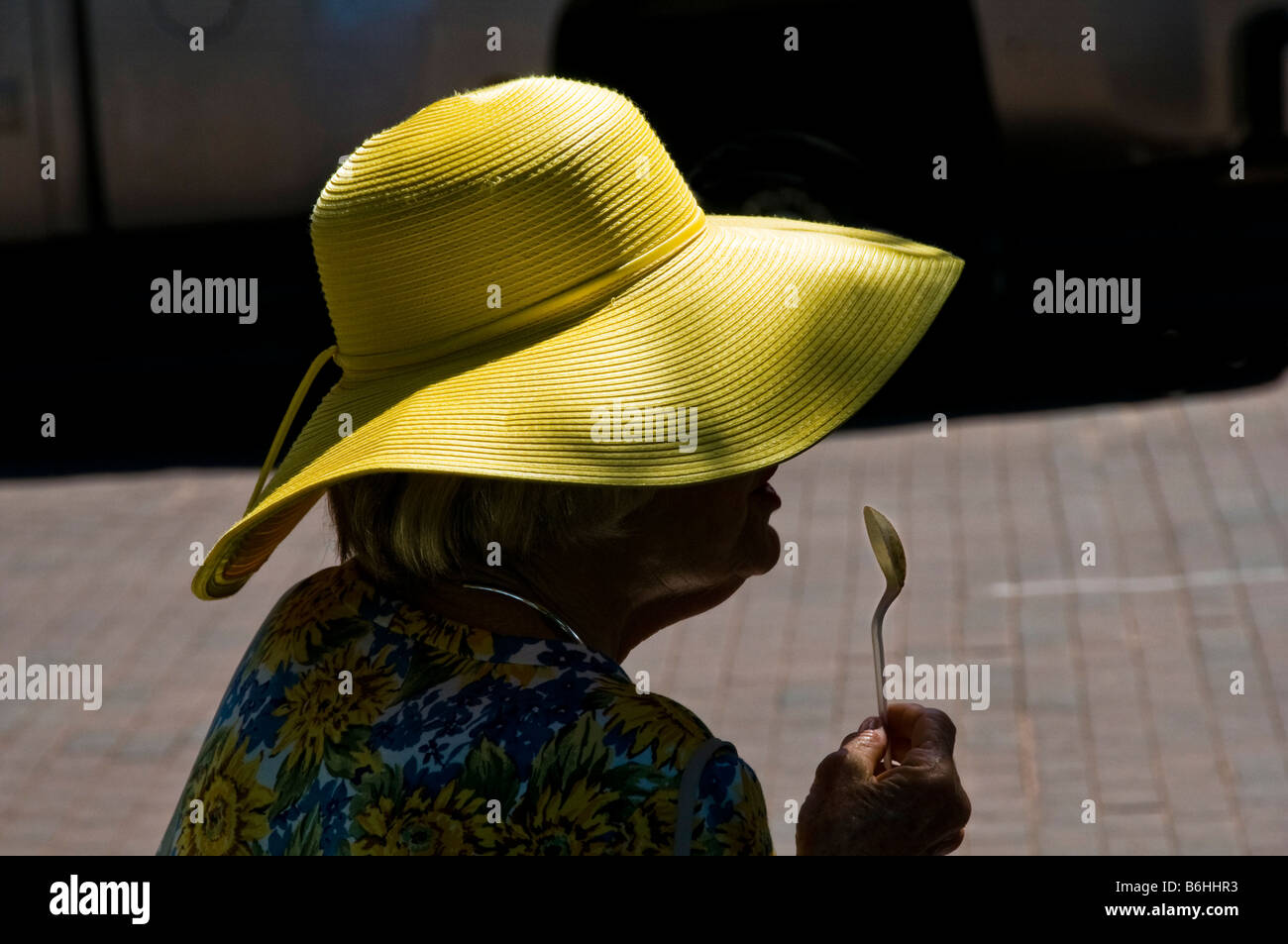 Donna anziana con cappello giallo leccare il cucchiaio dopo aver mangiato  il pranzo nel centro di Santa Fe NM Foto stock - Alamy