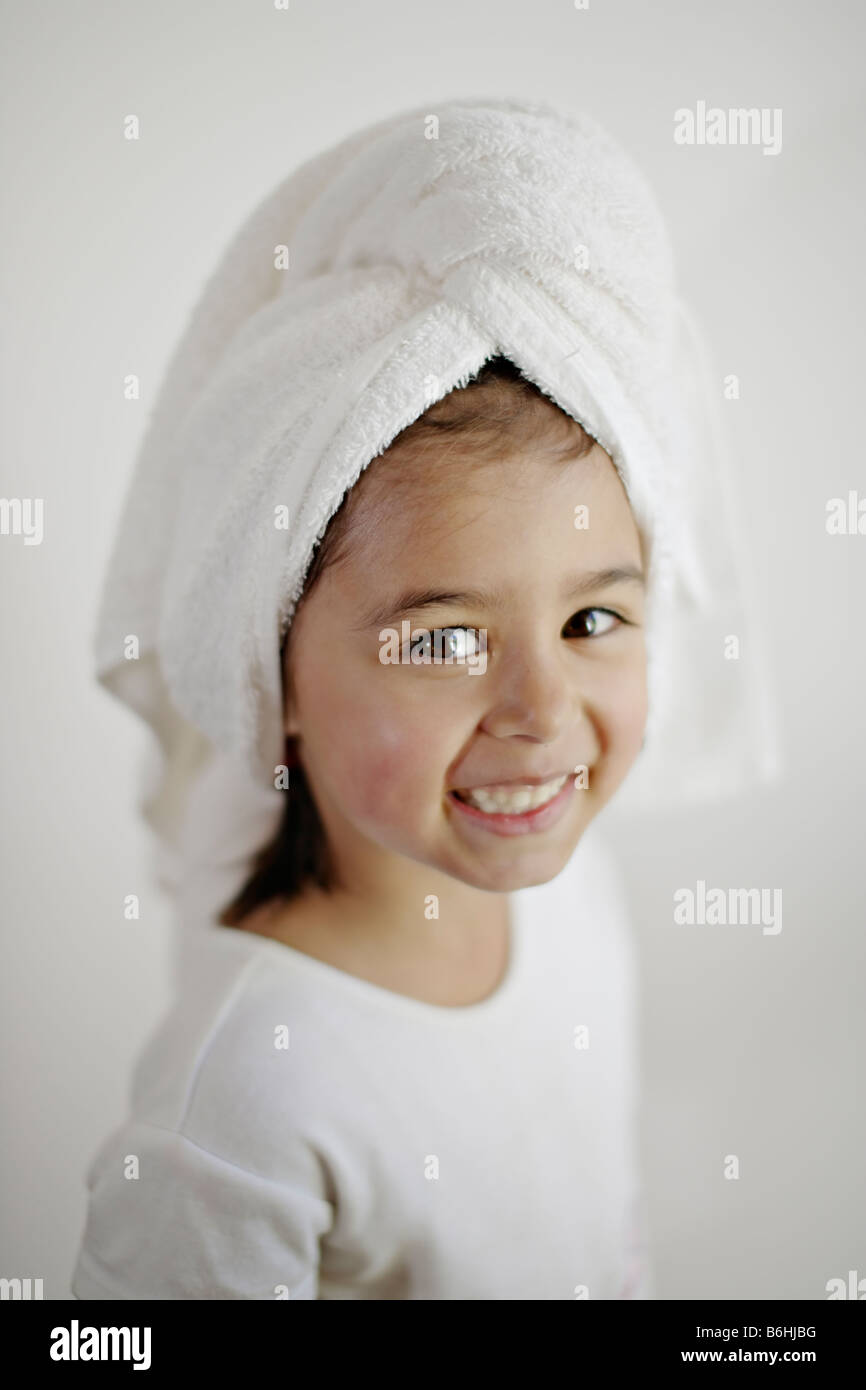 Bambina di cinque anni con capelli bagnati avvolto in asciugamano Foto Stock
