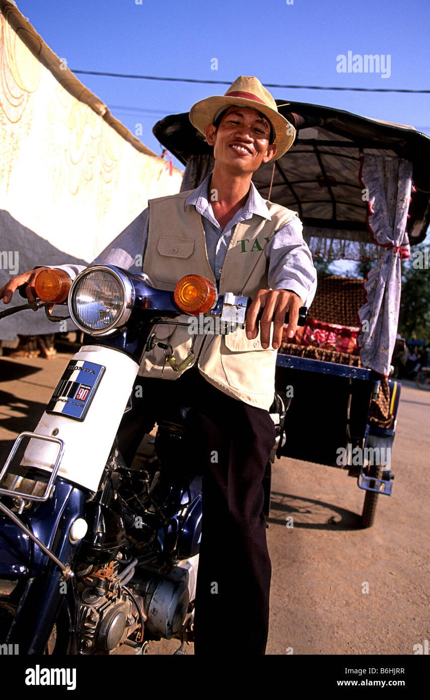 Driver di moto per le strade della cittadina turistica di Siem Reap, gateway al sito Patrimonio Mondiale dell'UNESCO rovine di Templi di Ankgor- Cambogia Foto Stock