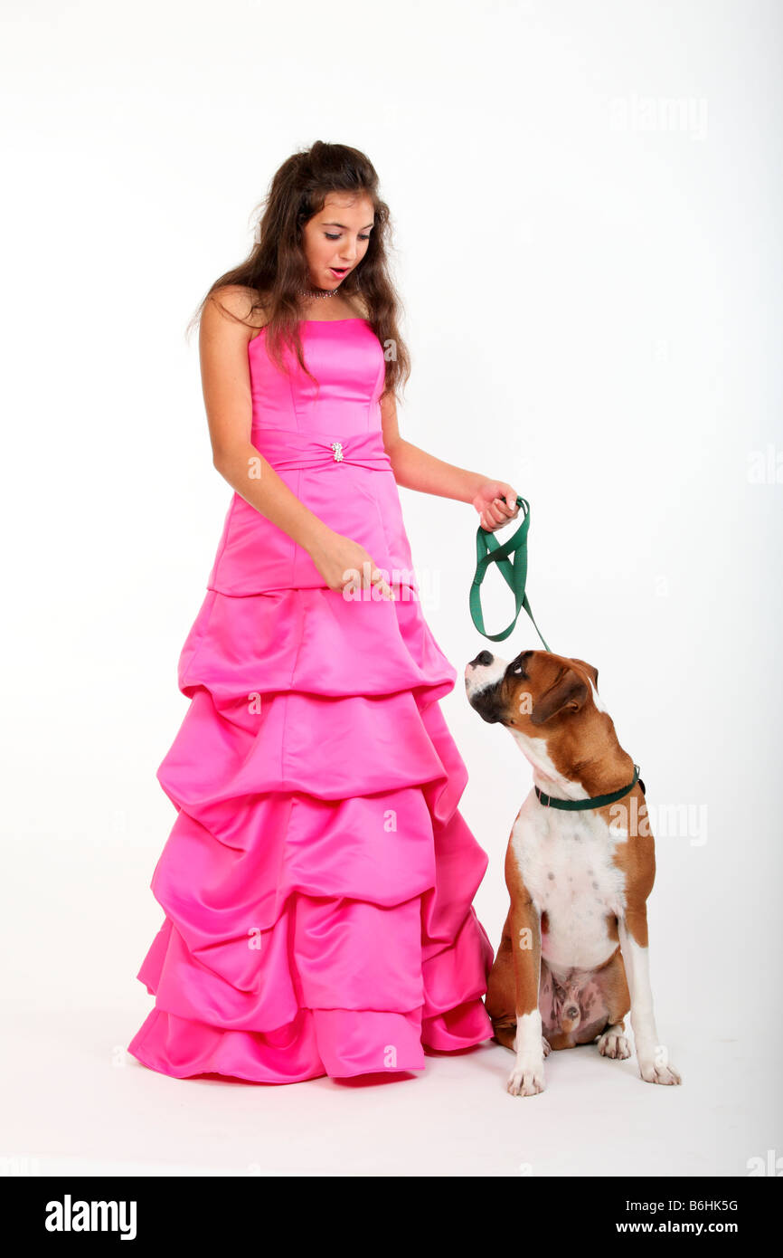Un teenager della ragazza in un abito di promenade e un boxer cane al guinzaglio Foto Stock