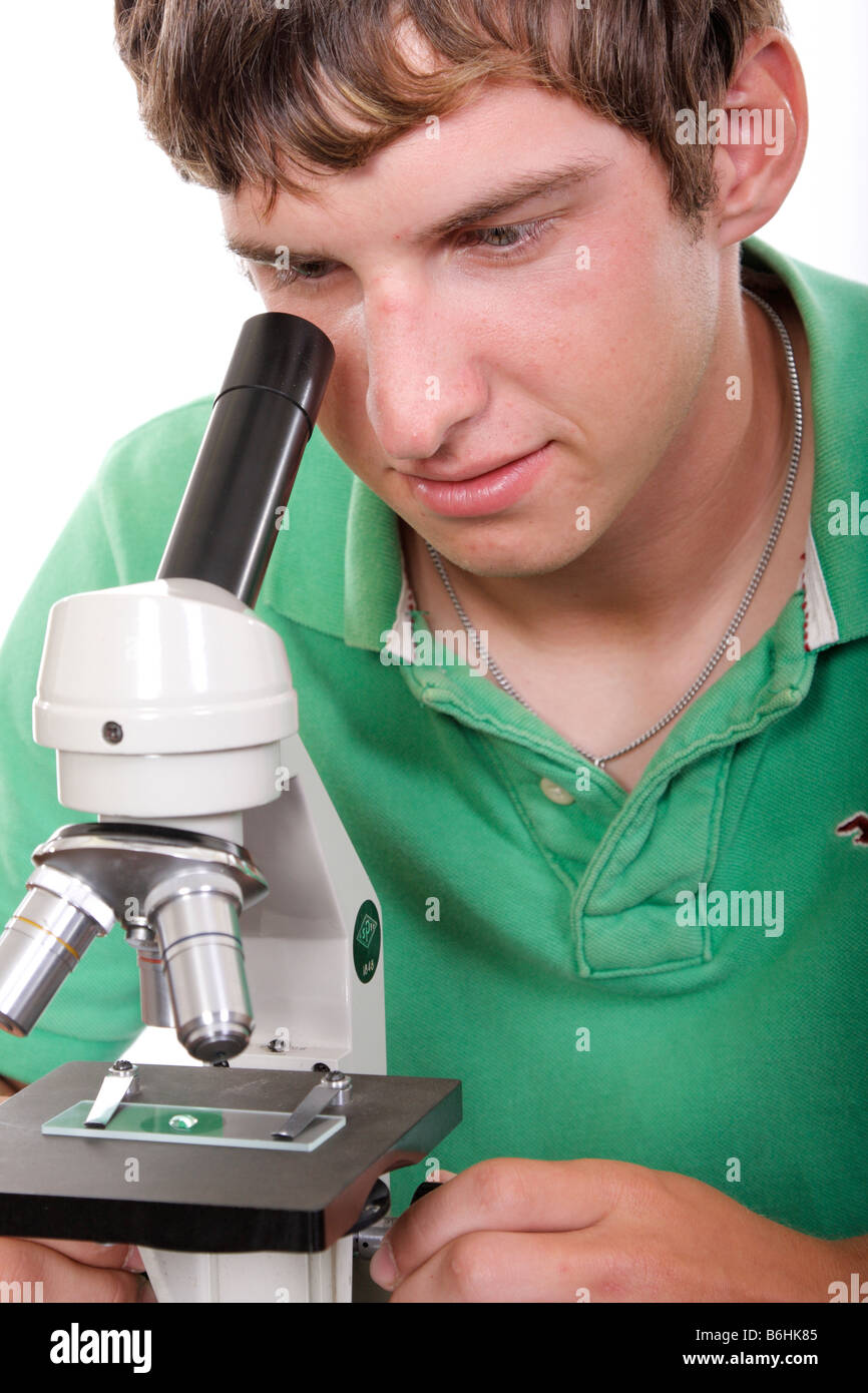 Un adolescente studente utilizzando un microscopio Foto Stock