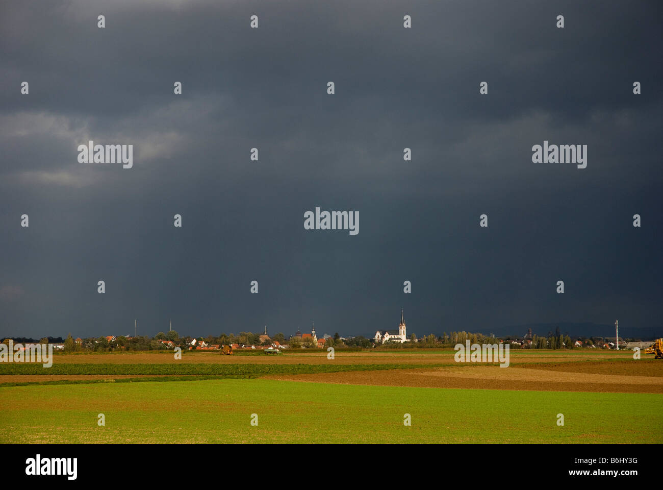 Piatto paesaggio agricolo con la Chiesa e con il cielo tempestoso nei pressi di Worms, Renania, Germania Foto Stock