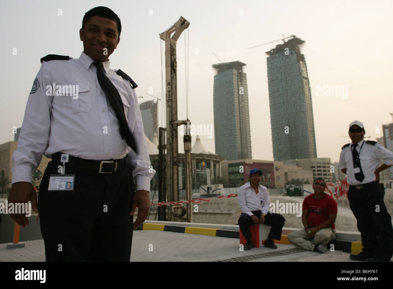 Gli immigrati lavorano come guardie di sicurezza nel centro di Doha, in Qatar. Foto Stock