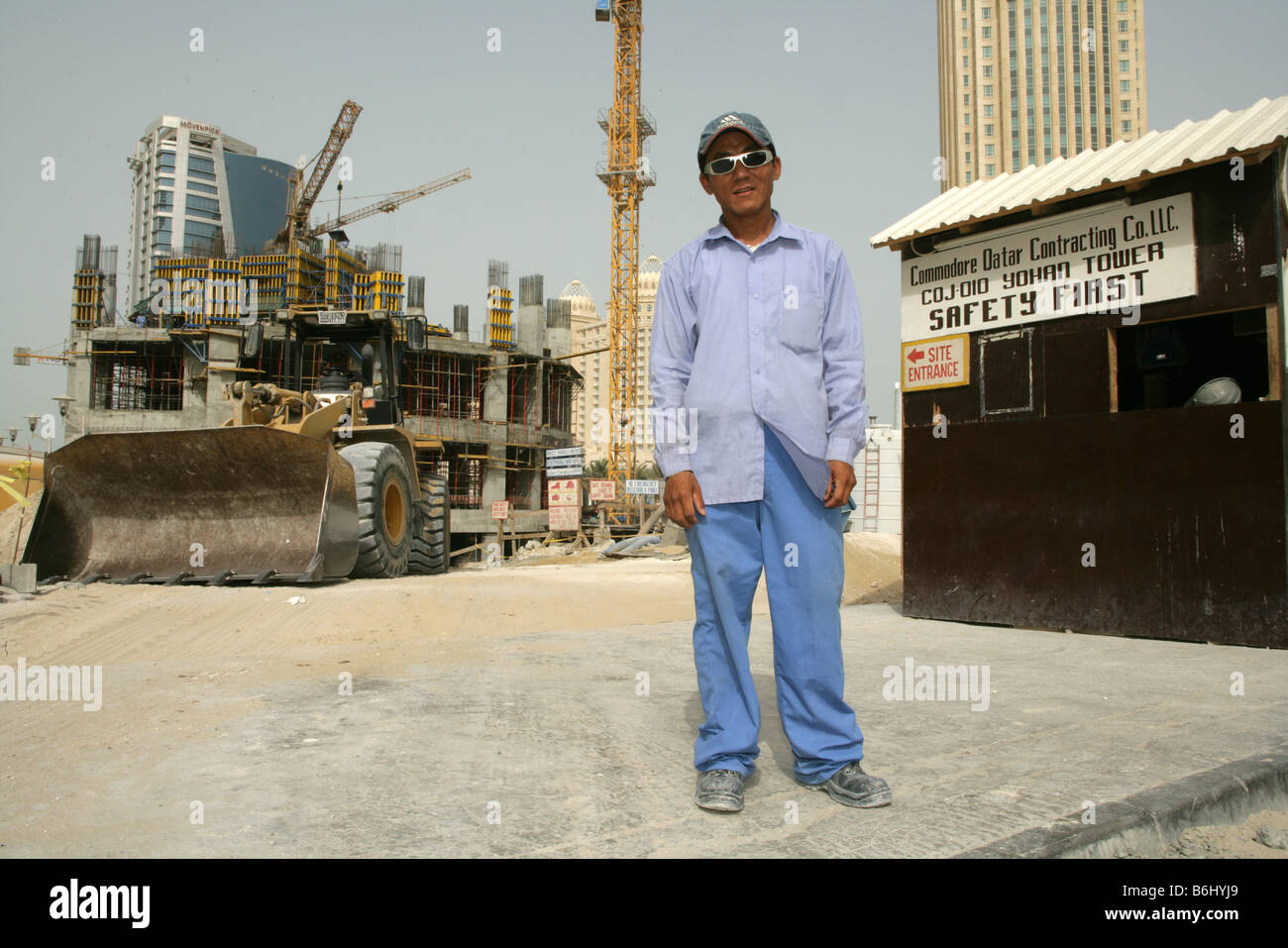 Migrante lavoratore di costruzione al cantiere di ingresso di sicurezza vicino al primo segno, ritratto, Doha, Qatar, Medio Oriente Foto Stock