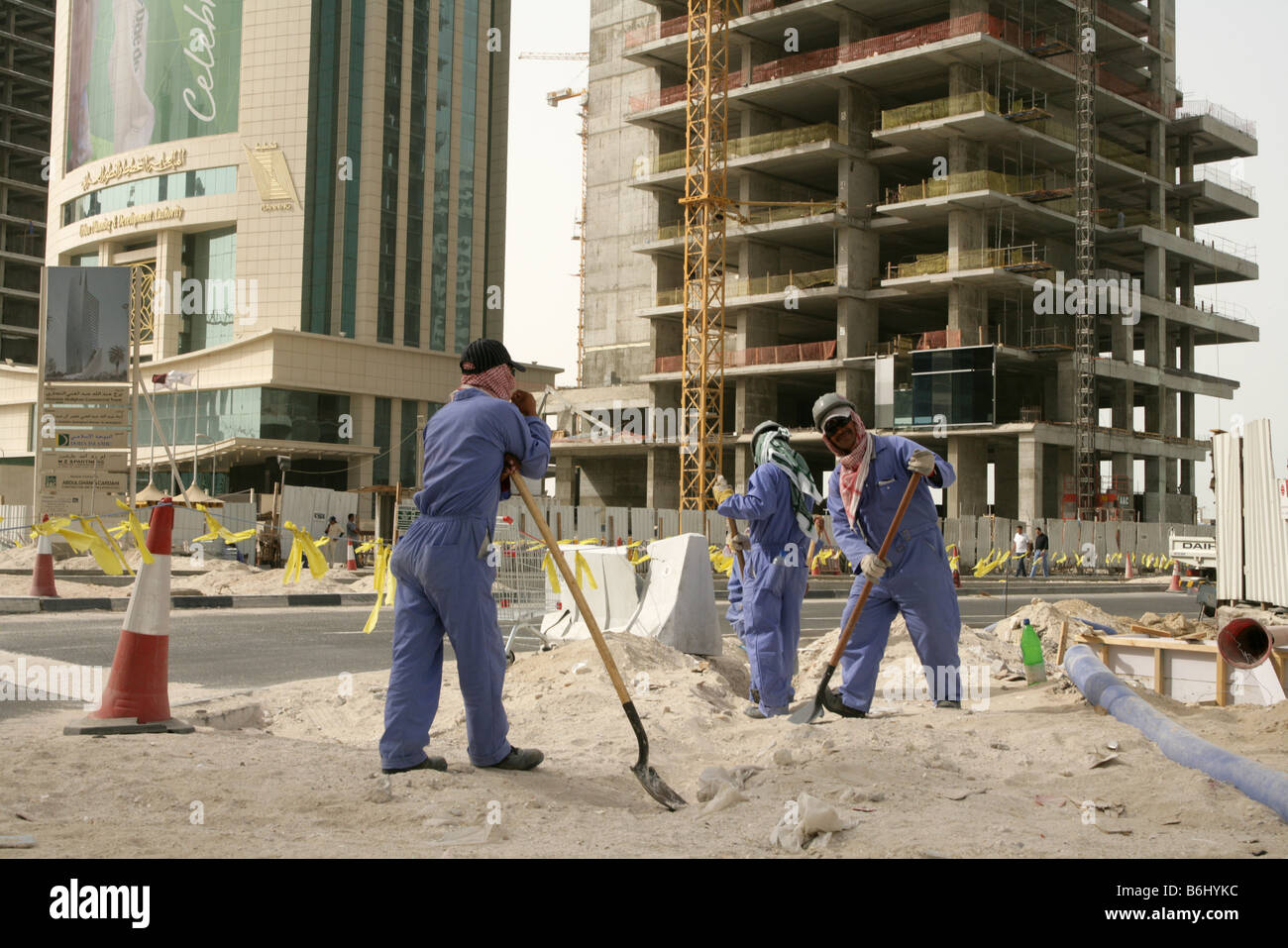Gli immigrati che lavorano in strada in costruzione a Doha, in Qatar. Foto Stock