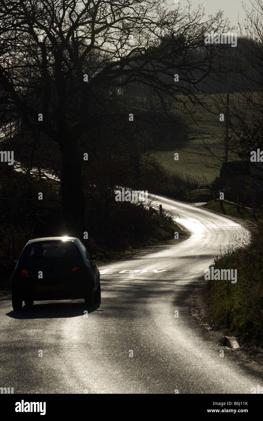 Auto viene guidato su un bendy country road, Boyton, Suffolk, Regno Unito. Foto Stock