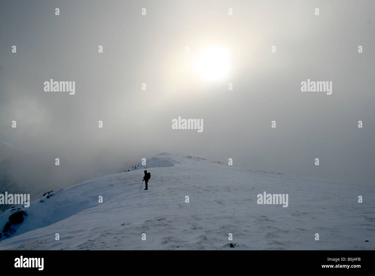 Fellwalking nella nuvola su Helvellyn è coperta di neve plateau sommitale, North East Lake District Foto Stock