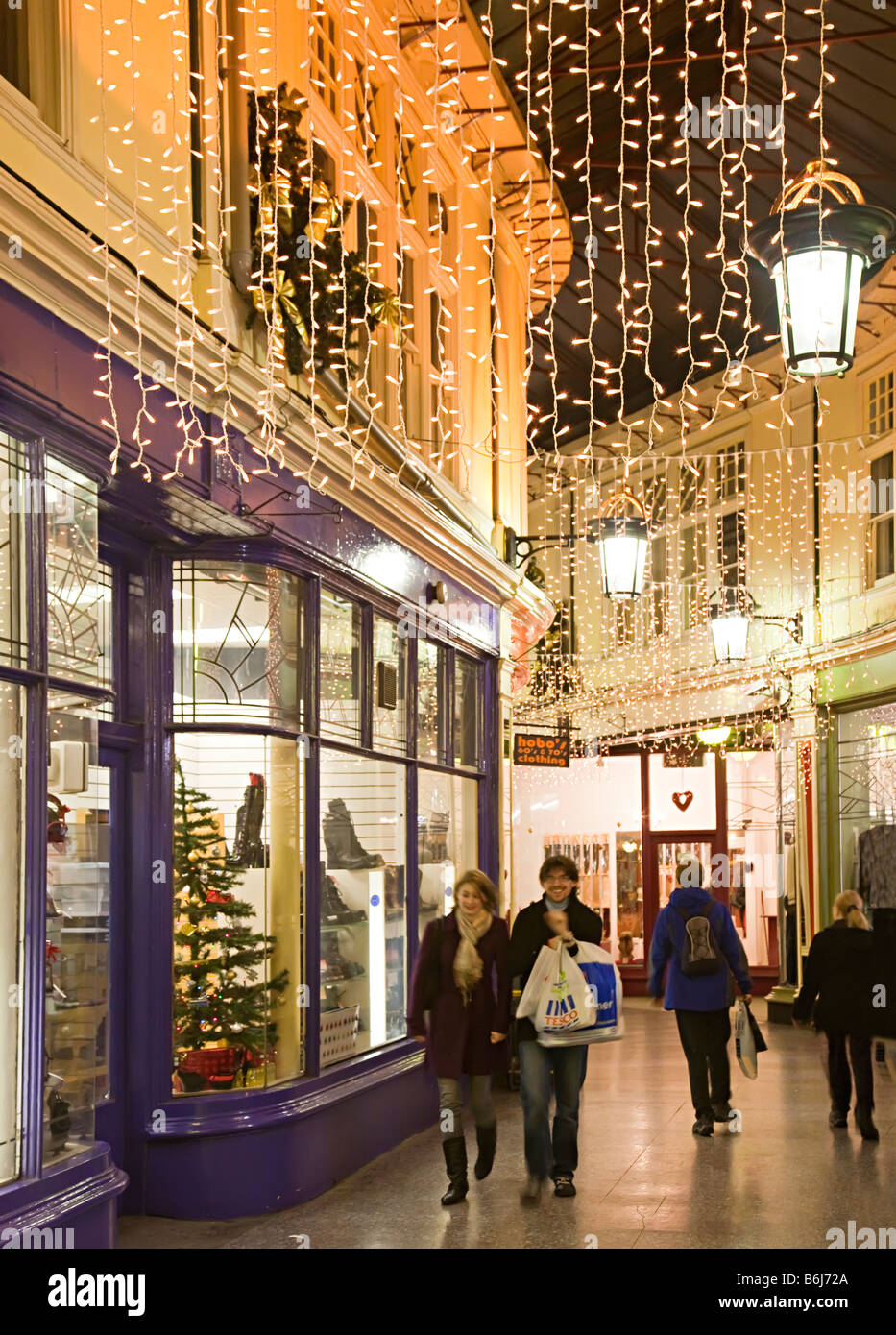 Gli amanti dello shopping a piedi attraverso Victorian shopping arcade a Natale Cardiff Wales UK Foto Stock