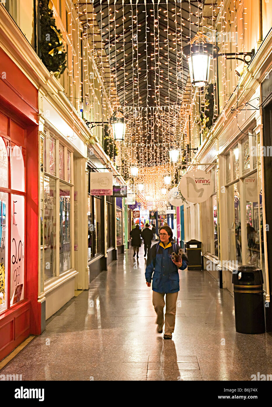 Gli amanti dello shopping a piedi attraverso Victorian shopping arcade a Natale Cardiff Wales UK Foto Stock