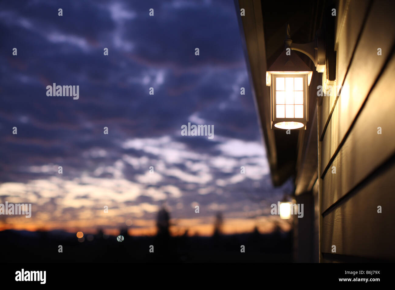 Luce su a casa la sera con NUVOLOSO TRAMONTO cielo Foto Stock