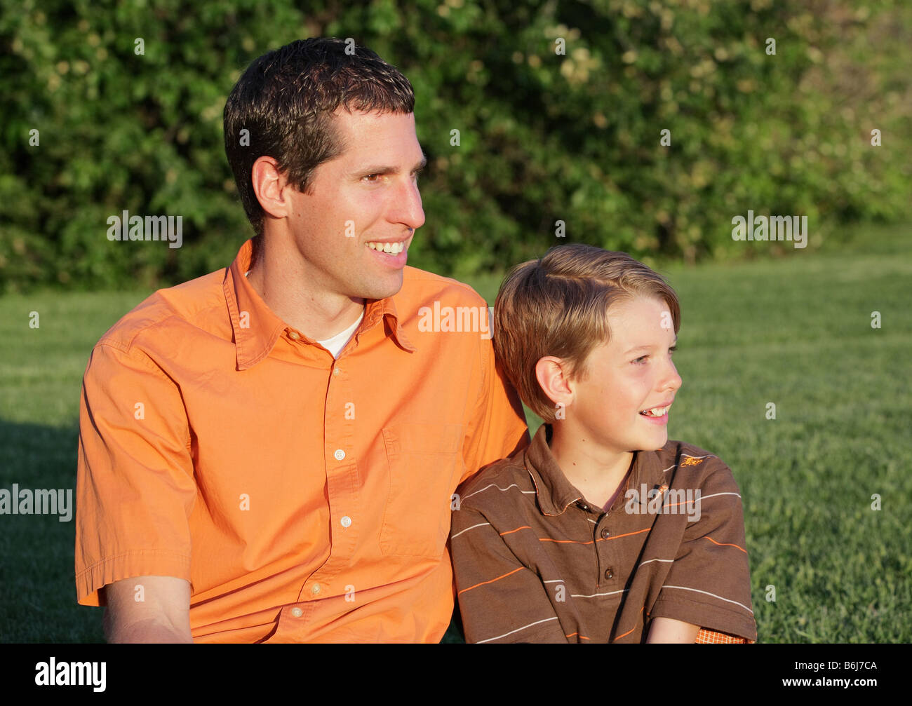 Felice padre e figlio seduti insieme al parco Foto Stock