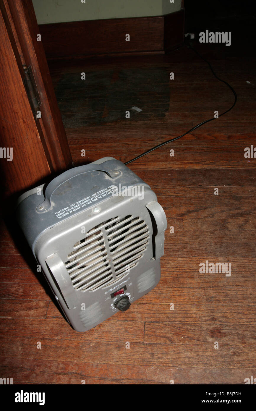 Piccolo spazio verticale della ventola del riscaldatore su pavimento di legno. Foto Stock