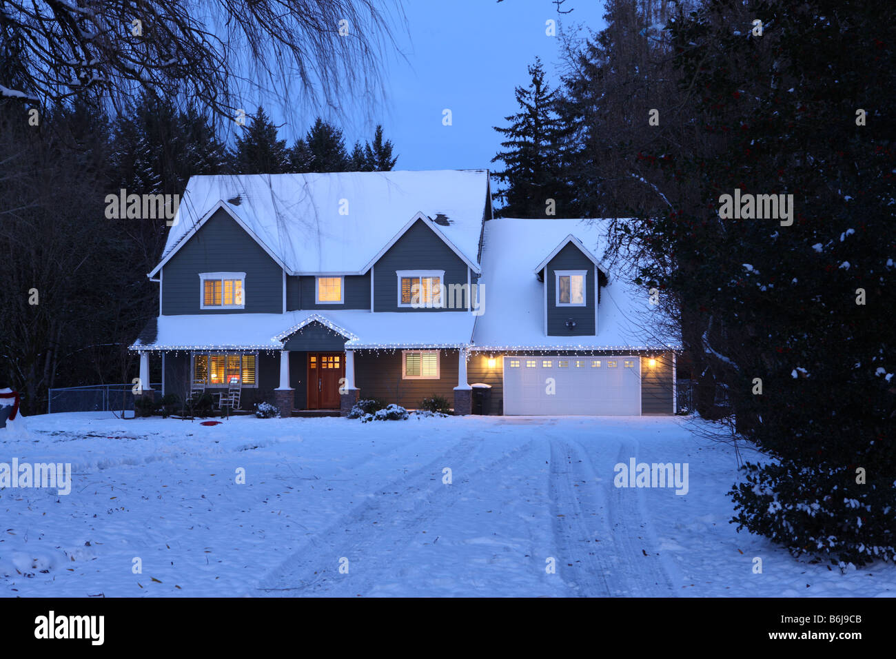 Inverno home casa durante la notte con le luci accese e la neve Foto Stock