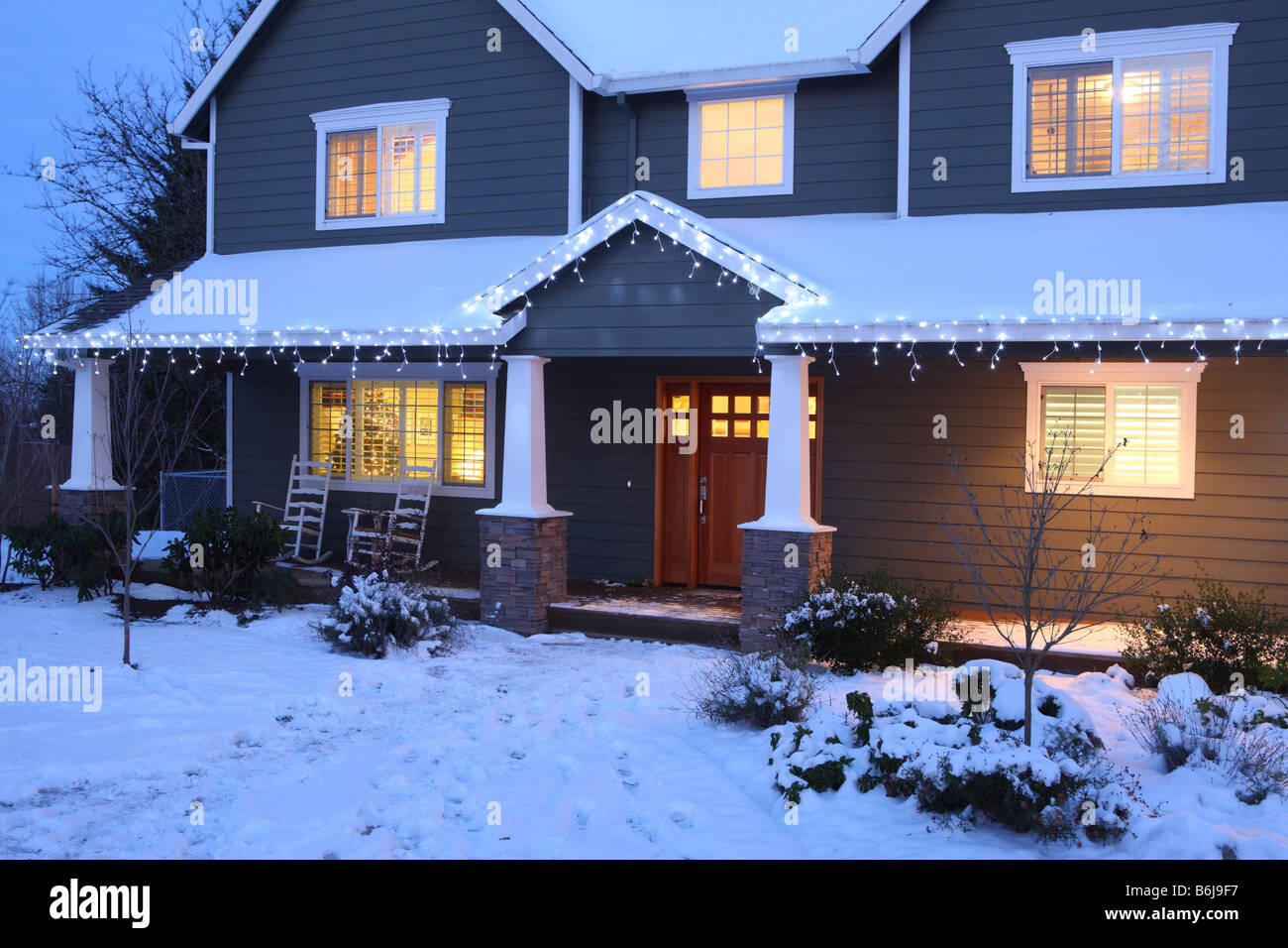 Inverno home casa durante la notte con le luci accese e la neve Foto Stock