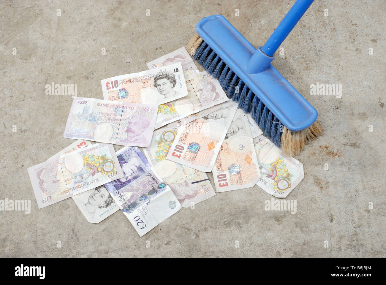Sterlina inglese banconote di essere spazzata con una scopa Foto Stock