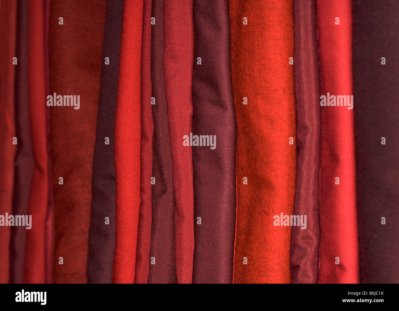 Pila di rosso borgogna e tessuti per abiti monastica. Il Tibet Foto Stock