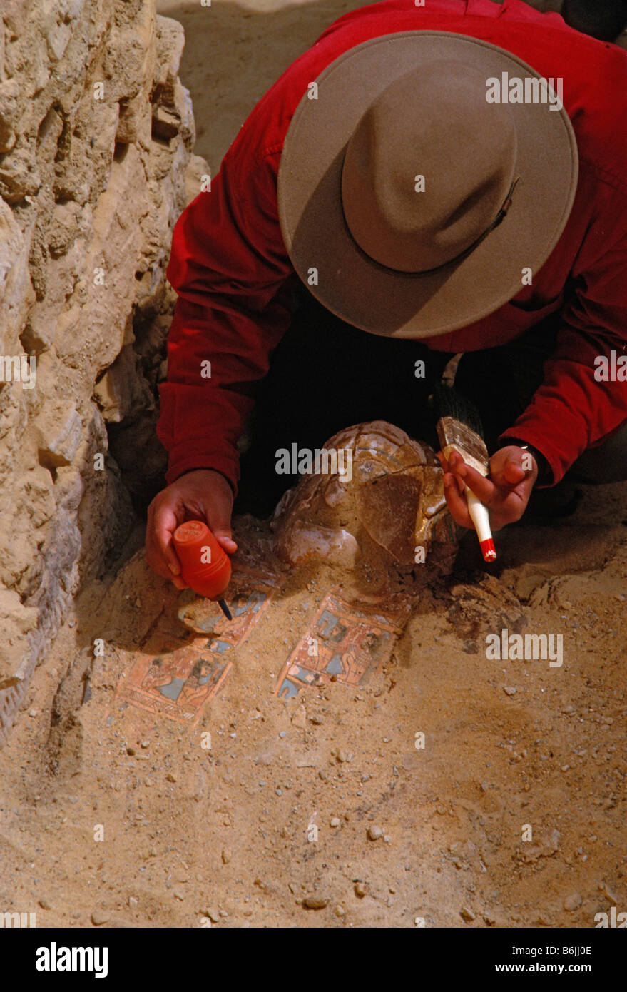 L'Egitto, la Valle delle mummie, Oasi Bahariya, Zahi Hawass in tomba 54 soffia sabbia da mummie Foto Stock
