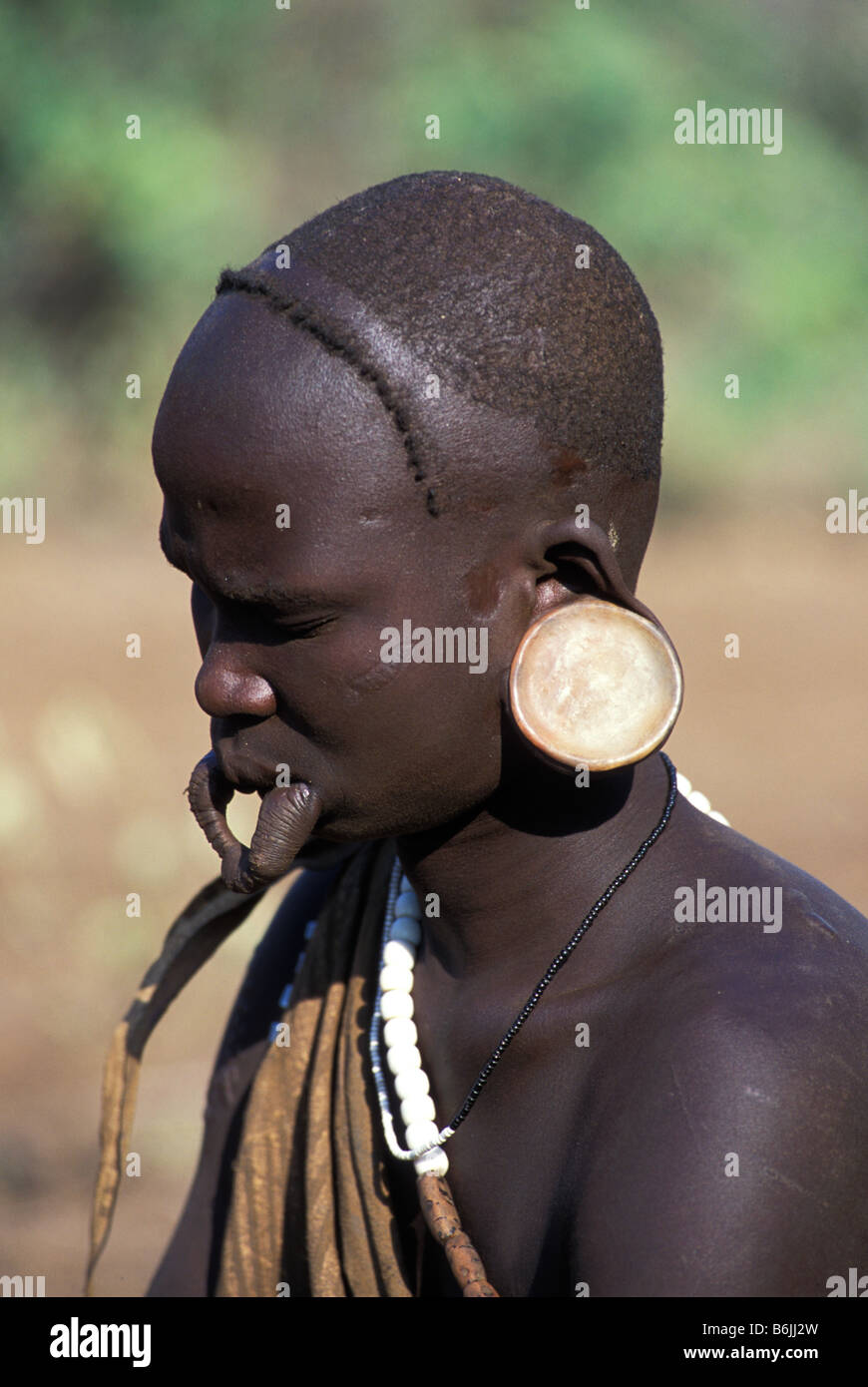 Africa, Etiopia, Omo regione, giovane Mursi con tradizionali piatti dell'orecchio, piastra a labbro rimosso (MR) Foto Stock