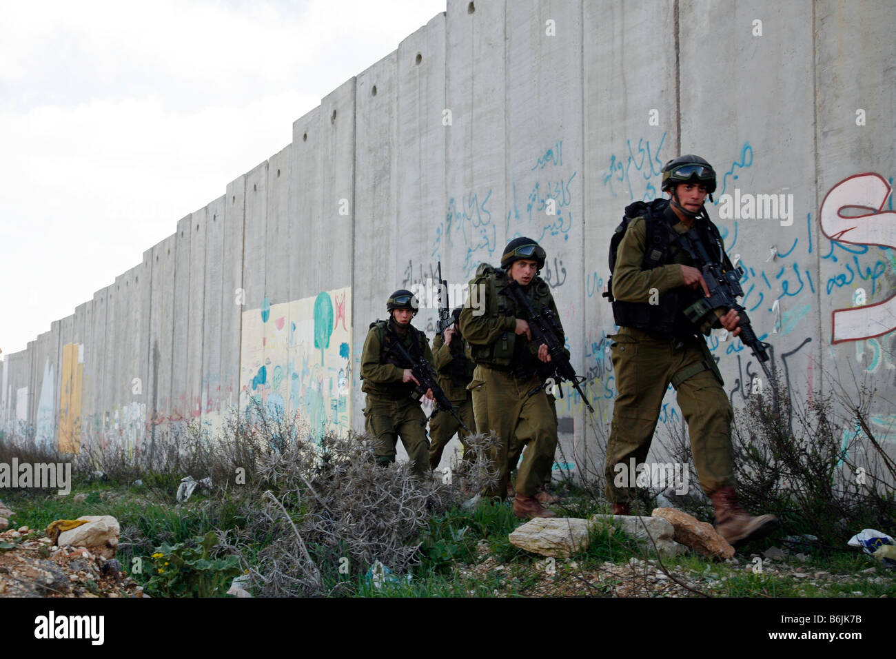 Soldati israeliani a piedi passato Israele la controversa barriera di sicurezza in Cisgiordania. Foto Stock