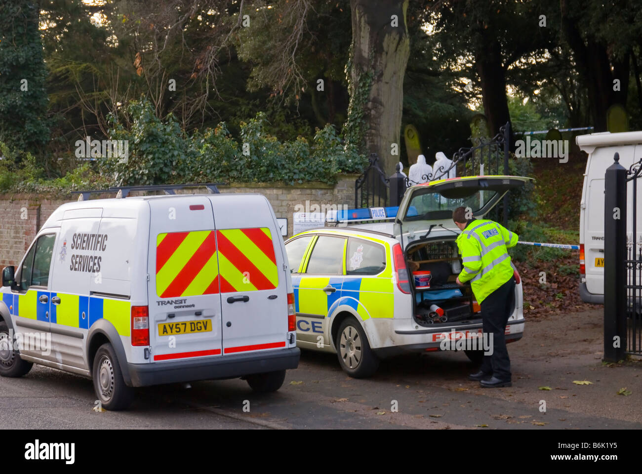 La polizia e gli ufficiali forensi alla ricerca di indizi dopo un crimine è stato commesso in un cimitero del Regno Unito Foto Stock