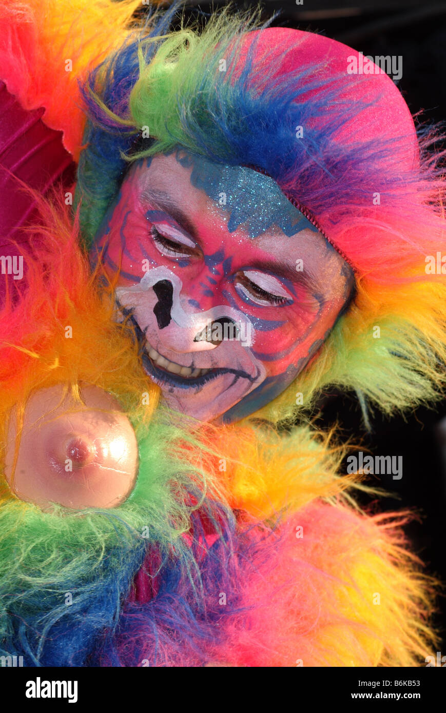 Clown south american style artista di strada theatre caleidoscopio multi colorata colorata arcobaleno faccia dipinta monkey thames festival Foto Stock