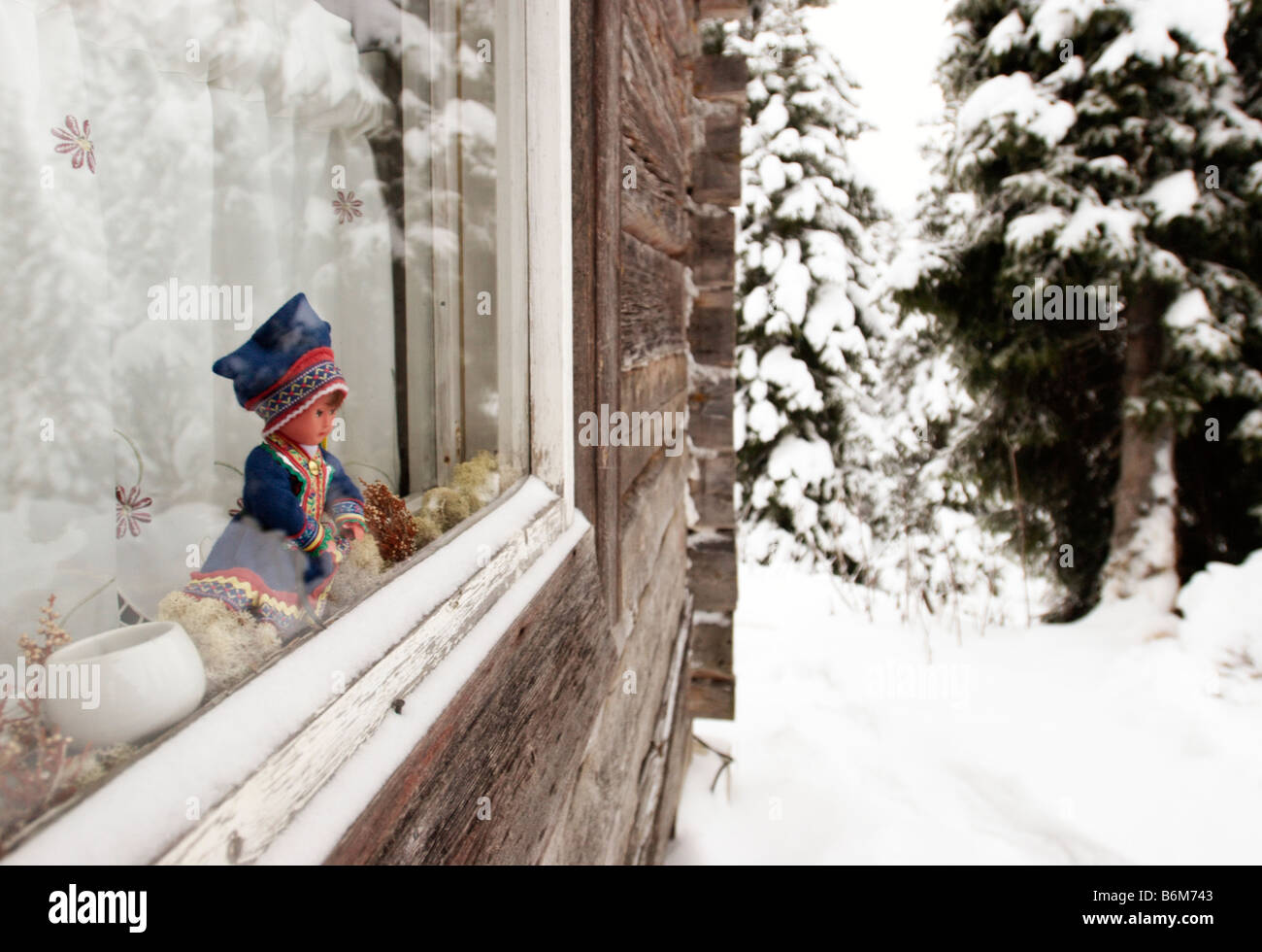 Bambola in Lappone tradizionale / Sami costume in una finestra di una capanna in legno, Kuusamo, Finlandia Foto Stock