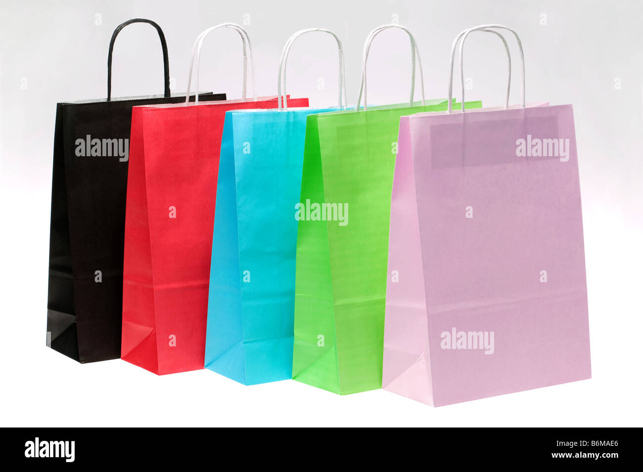 Carta cinque borse per lo shopping con luminose dei colori in una fila in corrispondenza di un angolo Foto Stock