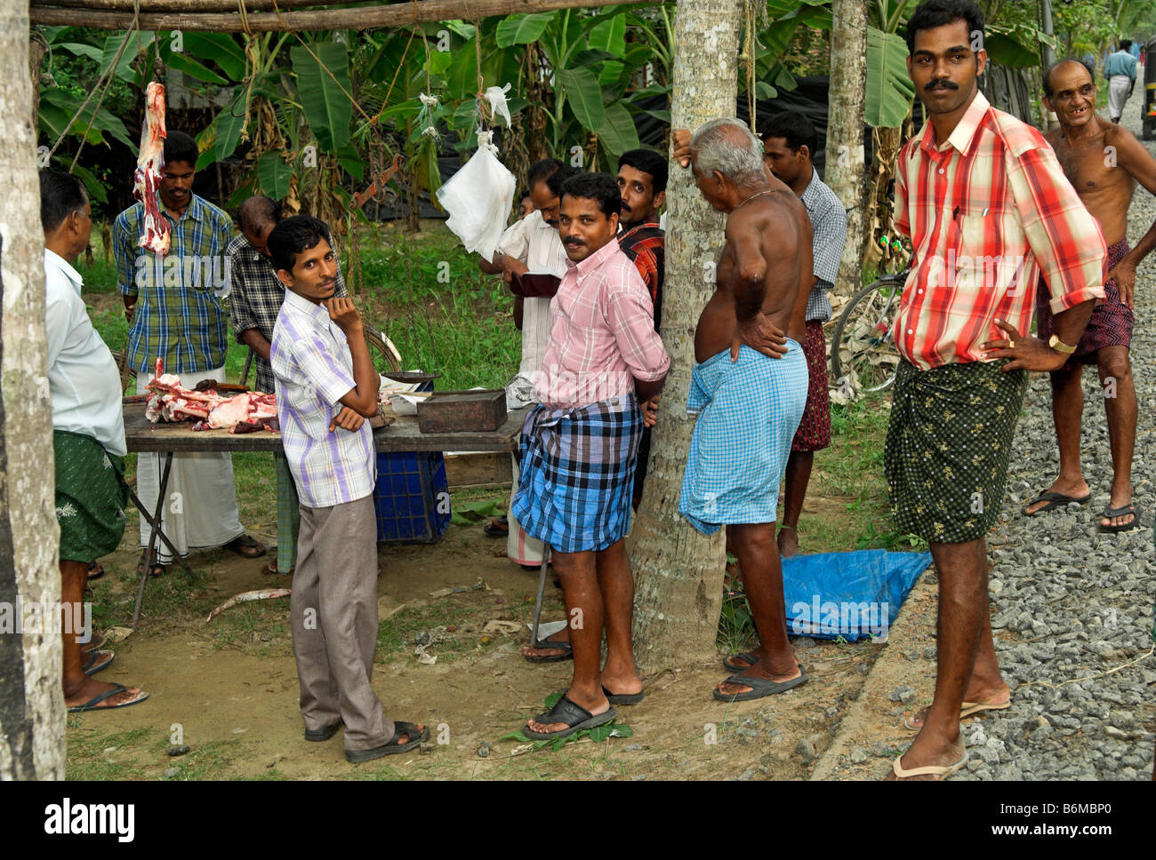 I clienti in India rurale in attesa come la carne viene tagliata in India Kerala Foto Stock