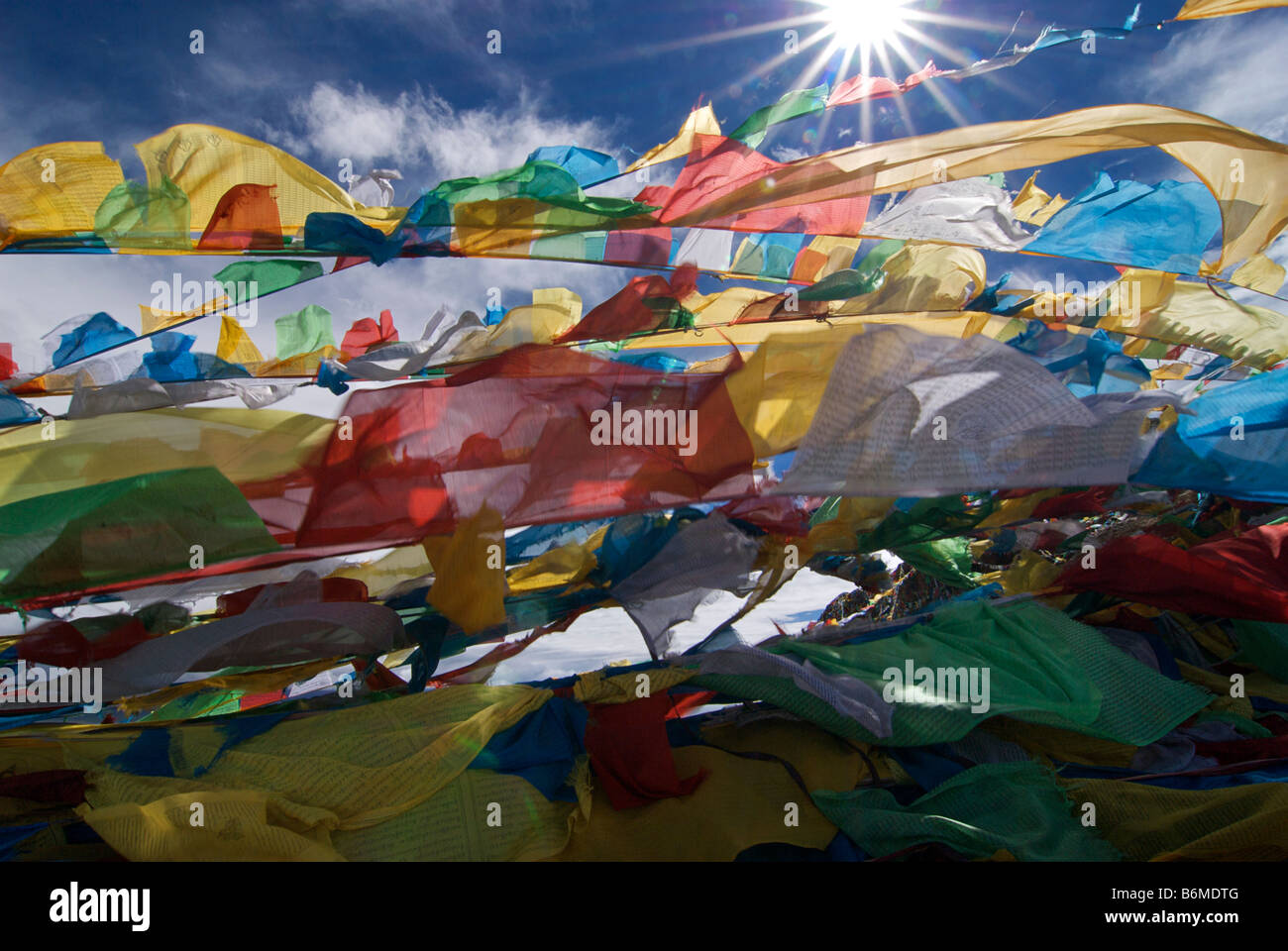 Bandiere di preghiera sbattimenti nel sole di mezzogiorno sulla cima di un affioramento al lago Namtso, Tibet Foto Stock