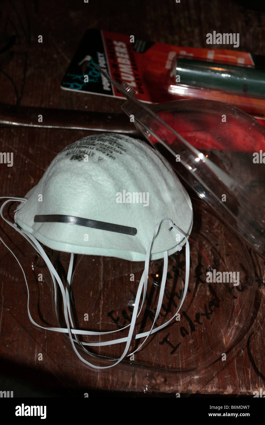La maschera antipolvere, martello, e altri strumenti e gli elementi in legno della superficie del piano portapaziente. Foto Stock