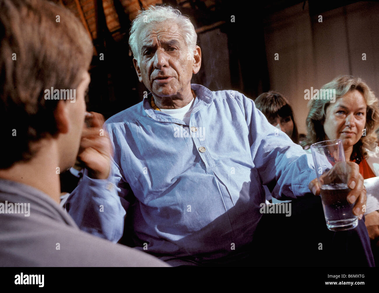 Leonard Bernstein parlando ai membri della Orchestra dei giovani egli sta conducendo in Salzau durante una pausa della prova Foto Stock