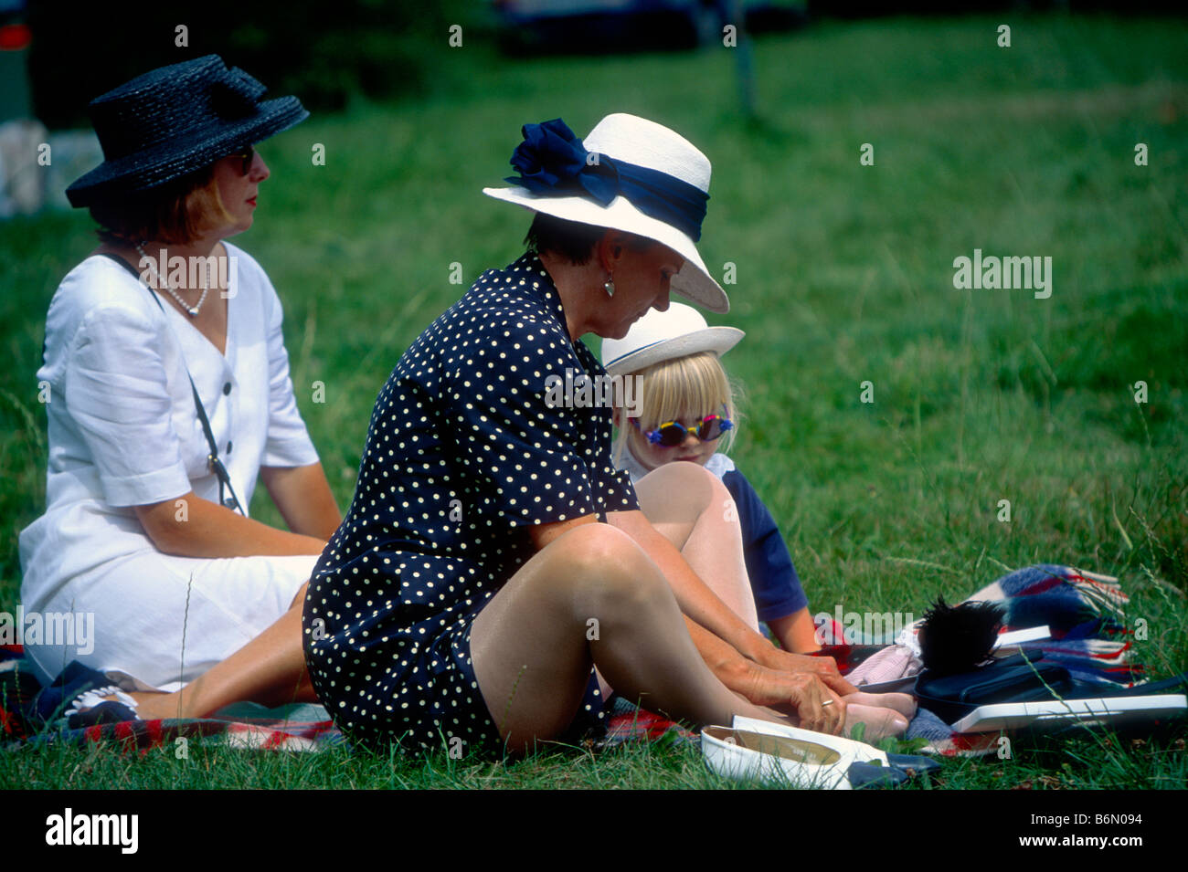 Vestiti da donna e bambino, i visitatori in Salzau mentre il Schleswig-Holstein-Music-Festival, facendo picnic in erba. Foto Stock