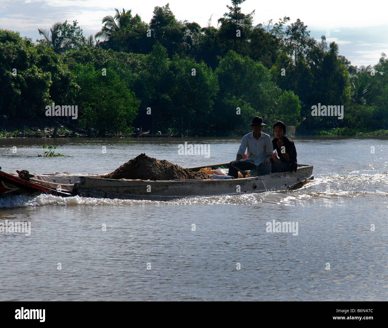 Due lavoratori sulla barca di grano, Delta del Mekong Foto Stock