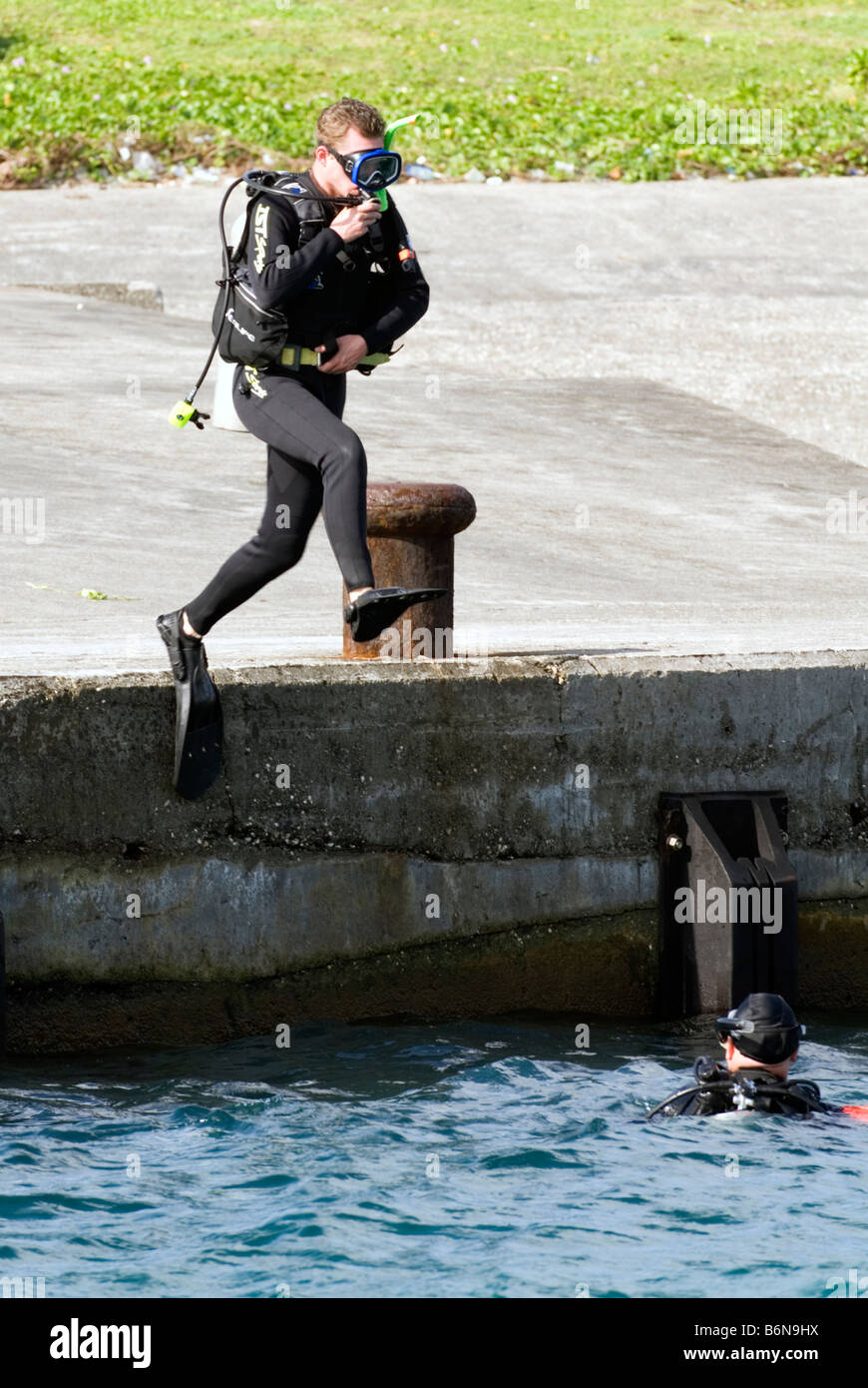 L'uomo vestito di attrezzatura subacquea Jumping nell'oceano, Taiwan, Isola Verde Foto Stock