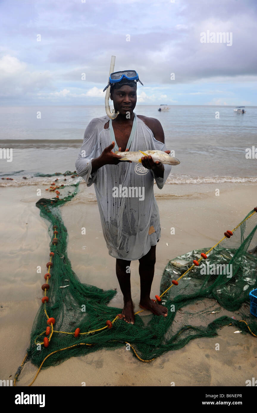 Un pescatore artigianale con una cattura da reti FUORI DALLA SPIAGGIA AL MORGAN BAY RESORT VICINO A CASTRIES ST LUCIA Foto Stock