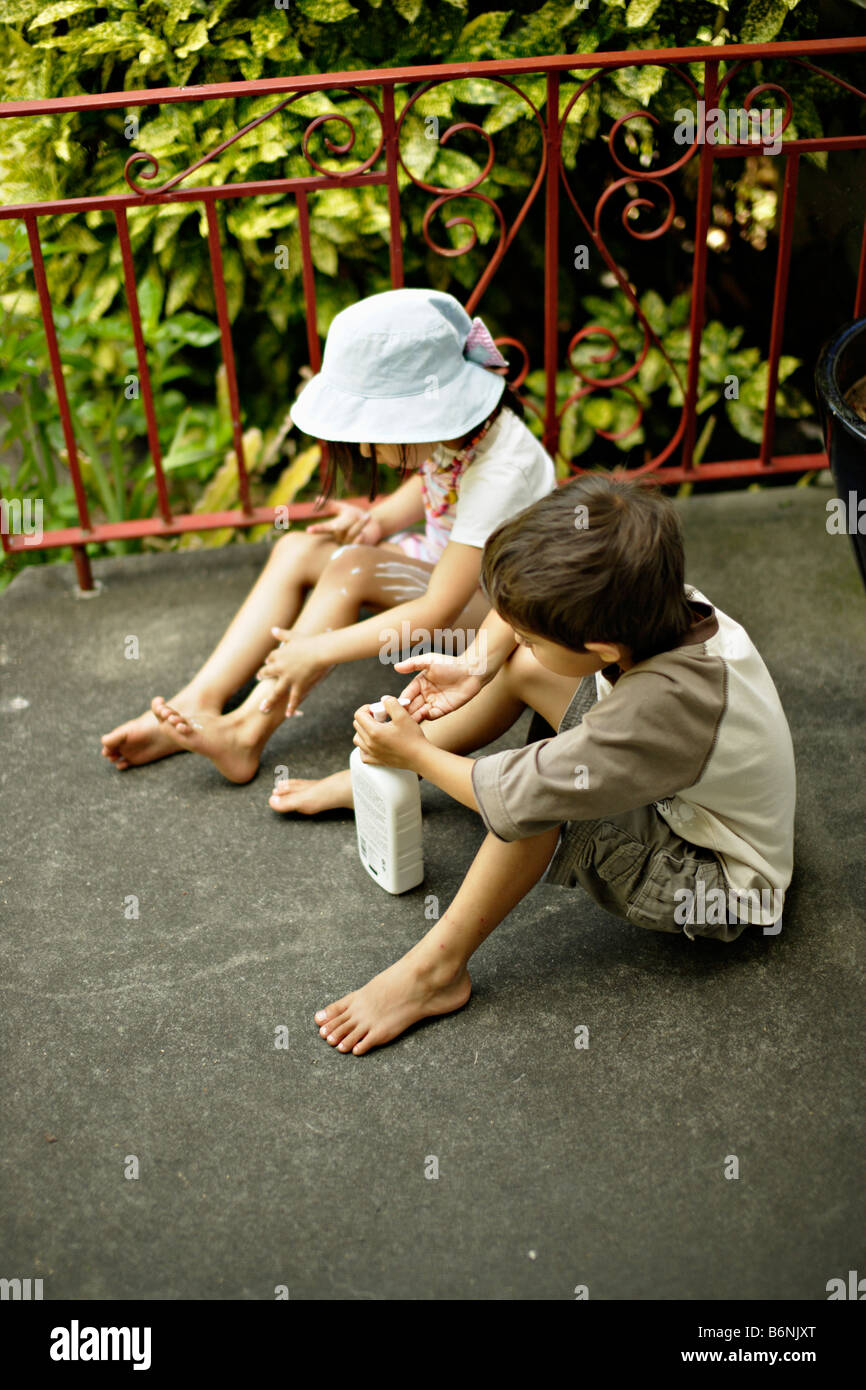 I bambini si applica la crema solare ragazzo di età compresa tra i sei ragazza all età di cinque anni Foto Stock